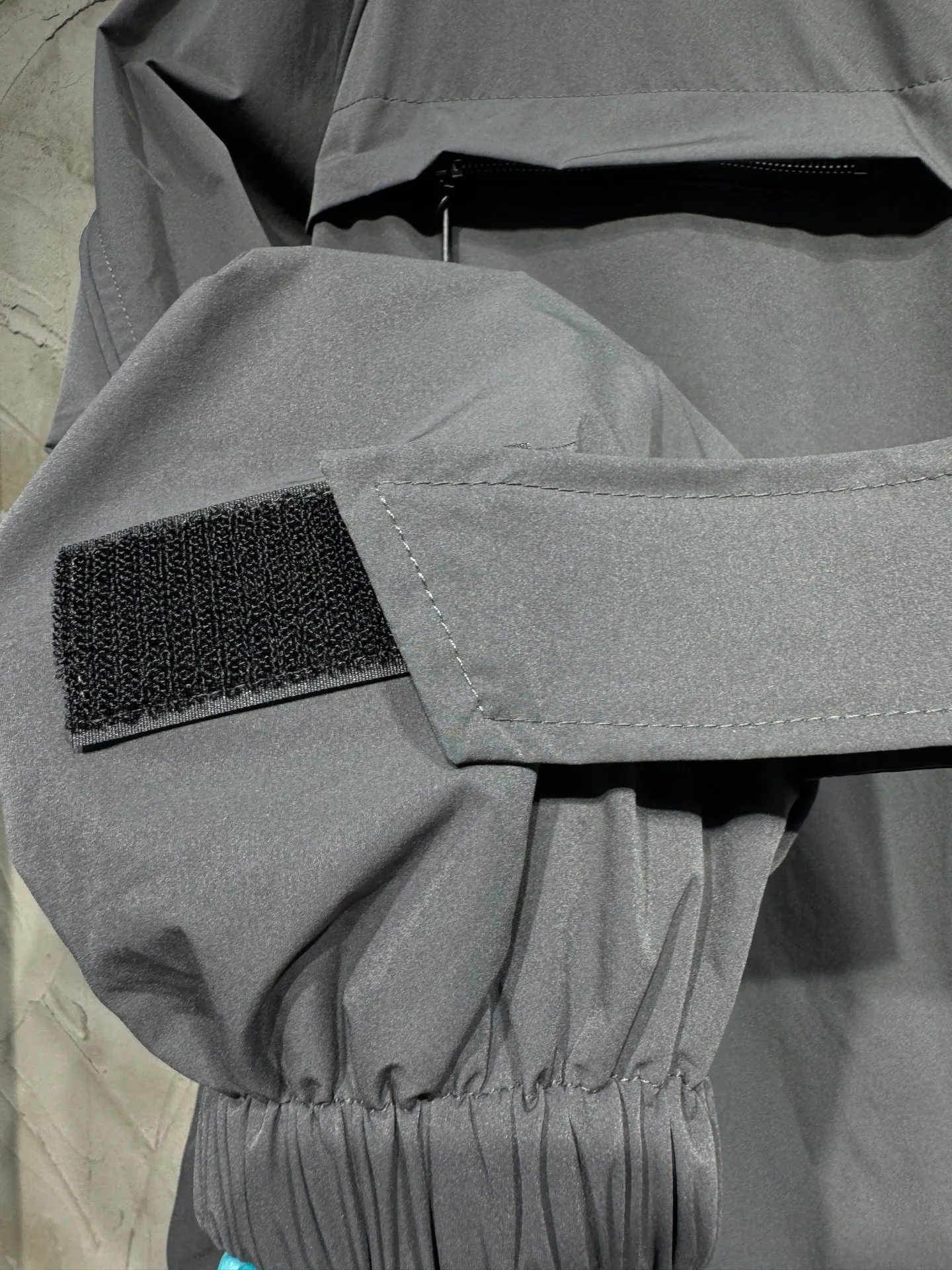 Acne Studios 26SS Large Lapel Short Jacket The fabric is made of 100% nylon (nylon/polyamide fiber) 75D high-density wrinkled nylon. The fabric has been permanently pressed and shaped by high temperature, and washed with high-pressure wrinkles at the factory to form its own irregular texture, permanently retaining the wrinkled texture, which will not disappear after washing. Matte matte coating removes the plastic glossy surface of nylon itself to create a low-key matte paper feel. Three-proof micro-coating, weak waterproof, anti-fouling, anti-static treatment, not easy to get dust. The interior is made of full-width mesh Breathable nylon lining, which reduces the stickiness of the nylon fabric to the body, improves air circulation, prevents sweating from sticking to the skin, and the zipper does not rub against the skin. The version adopts the raglan split topstitching process, and the front and rear panels are divided diagonally to expose even stitching. The three-dimensional dropped shoulders are loose and the fit is increased to increase the margin of movement. The back neckline is three-dimensional and high-density computer embroidered, and the embroidery lines are dense and not prickly. Customized all-metal matte nylon zipper, Genuine Leather embossed brand letters on the zipper leather tab, zipper tape with same color nylon fit to the body, double-locked reinforcement on both sides of the zipper to prevent pulling and tearing. Color: Gray Size: S M L